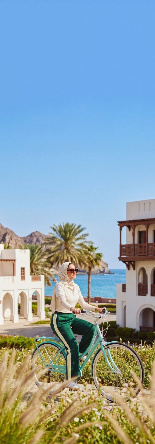 Cyclist riding through vibrant Muscat neighbourhood