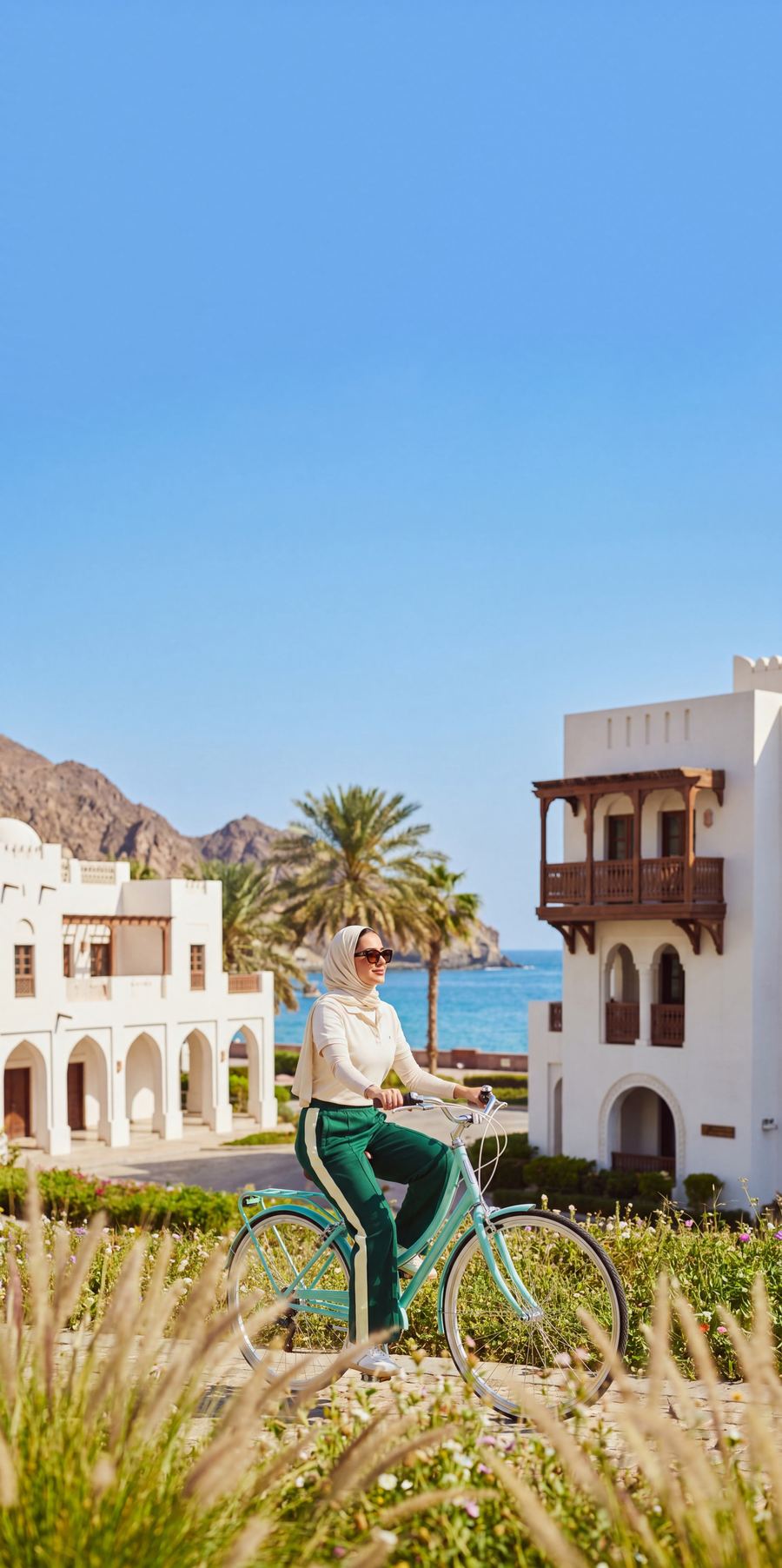 Cyclist riding through vibrant Muscat neighbourhood